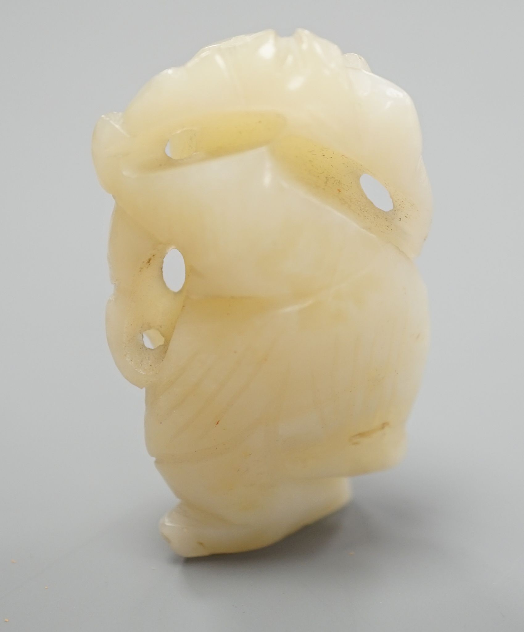 A Chinese bowenite jade carving of a boy with a branch, 5.5 cms high.